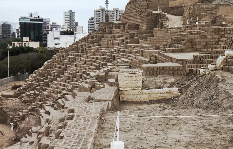 Huaca Pucllana archaeological ruins in Lima with city buildings in the background, historic site visited by travelers